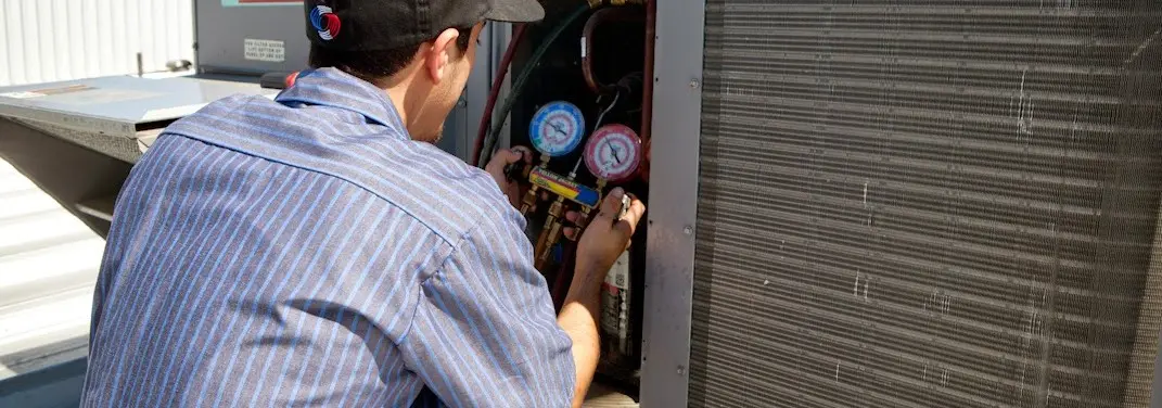 HVAC technician servicing a condenser unit in Rainbow Springs