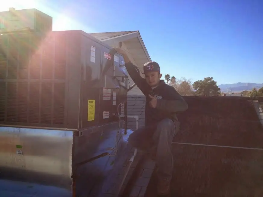 HVAC technician performing AC Tune-Up on a rooftop unit in Rainbow Springs
